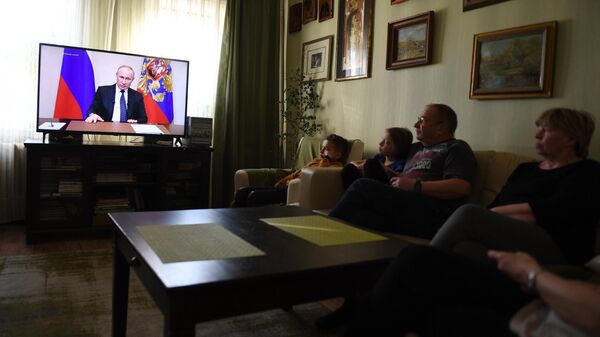 Жители Москвы смотрят у себя дома трансляцию обращения президента России Владимира Путина к гражданам из-за ситуации с коронавирусом
