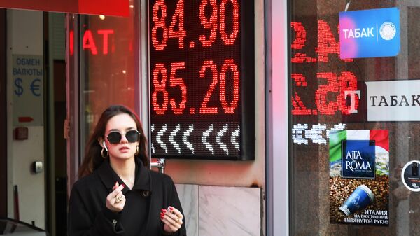 Девушка возле электронного табло с курсами валют в Москве