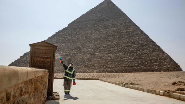 Рабочий во время дезинфекции комплекса пирамид в Гизе