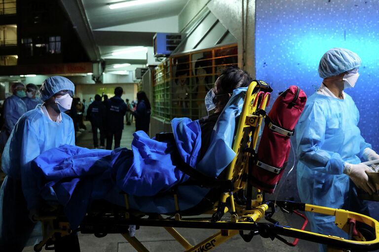 Бригада скорой помощи доставляет пациента в больницу в Гонконге Бригада скорой помощи доставляет пациента в больницу в Гонконге