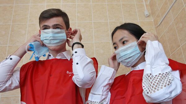 Волонтеры надевают медицинские маски перед тем, как пойти в магазин в Барнауле