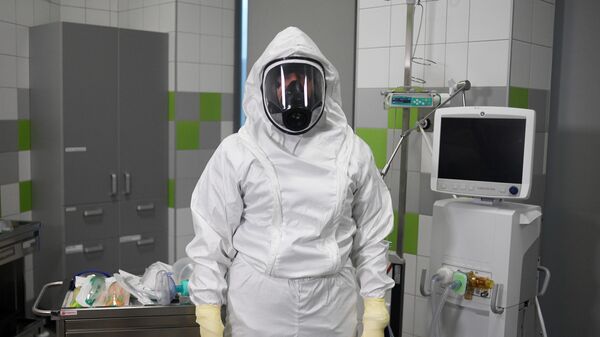 Врач в защитном костюме в боксе экстренной медицинской помощи Ильинской больницы