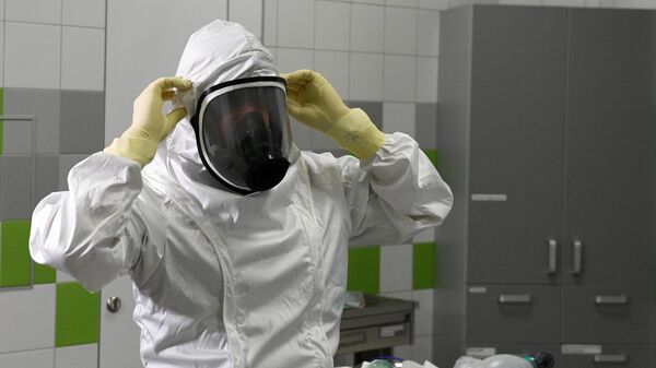 Врач в защитном костюме в боксе экстренной медицинской помощи Ильинской больницы