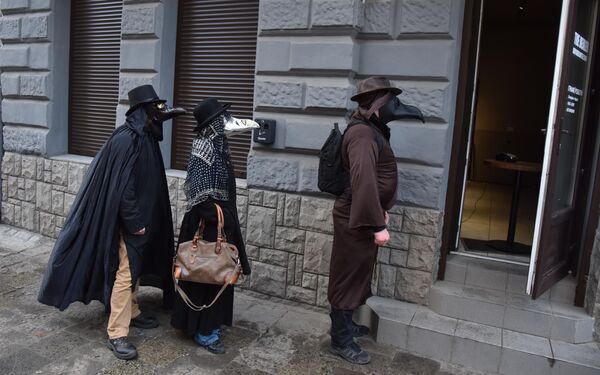 Прохожие в масках Чумного доктора на улице во Львове, Украина 