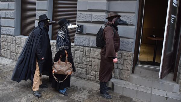 Прохожие в масках Чумного доктора на улице во Львове, Украина 