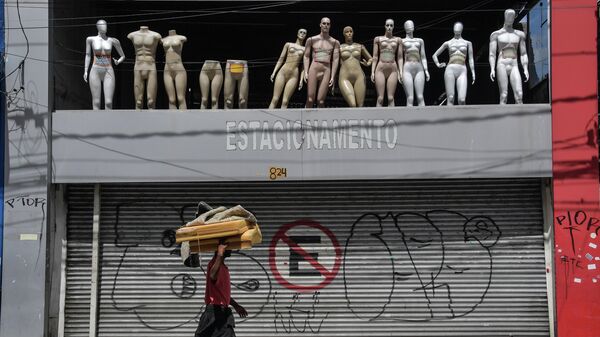 Мужчина проходит мимо закрытых магазинов в центре Сан-Паулу, Бразилия