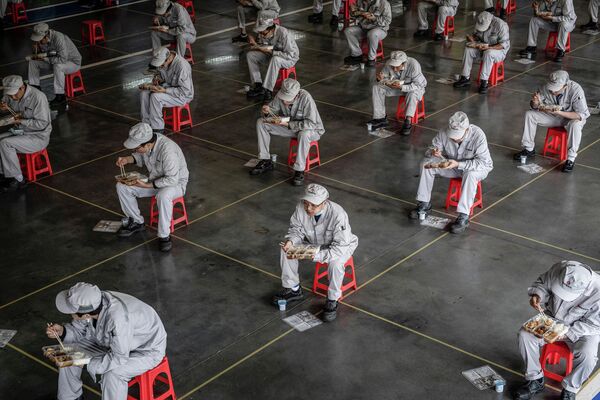 Сотрудники автомобильного завода в Ухане во время обеденного перерыва