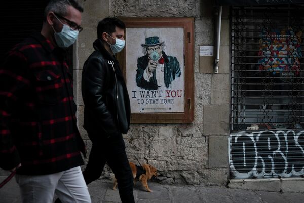 Люди проходят мимо плаката с текстом Я хочу, чтобы вы оставались дома, созданного уличным художником TvBoy  в Барселоне, Испания 
