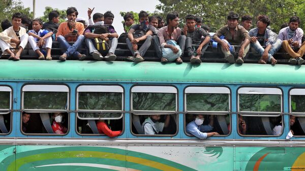 Люди едут в переполненном автобусе, чтобы вернуться в свои города и деревни до начала блокады правительством штата Западная Бенгалия в Калькутте, Индия