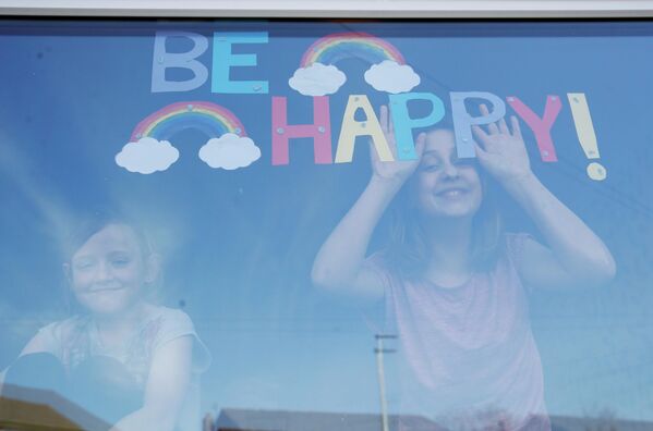 Дети в окне своего дома в Сент-Хеленсе, Великобритания