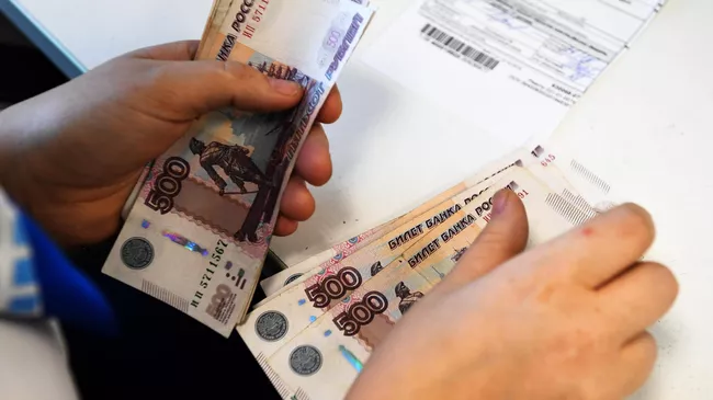 Сотрудница Почты России выдает пособие пенсионерке
