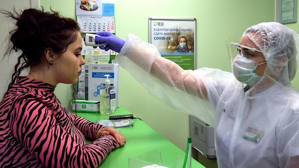 Замер температуры у пациентки  в частной лаборатории в Санкт-Петербурге, где проводится тестирование на коронавирус