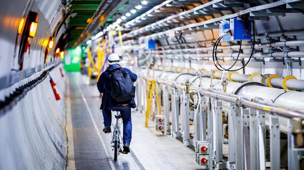 Мужчина едет на велосипеде вдоль Большого Адронного Коллайдера в туннеле Европейской организации ядерных исследований (ЦЕРН)