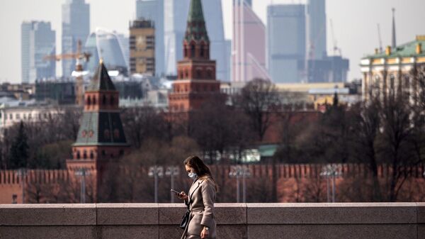 Девушка в медицинской маске во время прогулки в Москве
