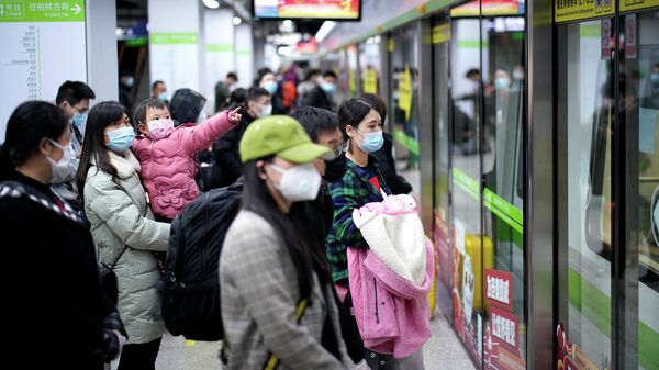 Пассажиры в защитных масках на одной из станций метро в Ухани, КНР. 28 марта 2020