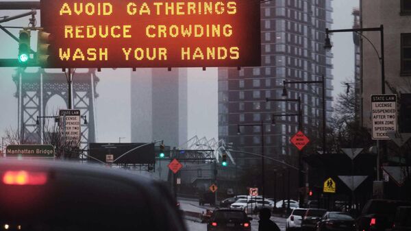 Табличка с предупреждением избегать скопления людей и мыть руки, расположенная на въезде на Манхэттенский мост в Нью-Йорке