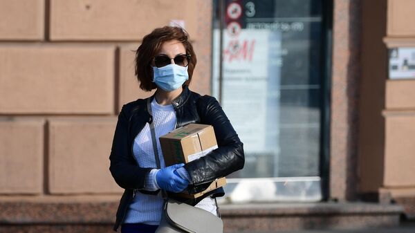 Девушка в медицинской маске и перчатках на улице Москвы