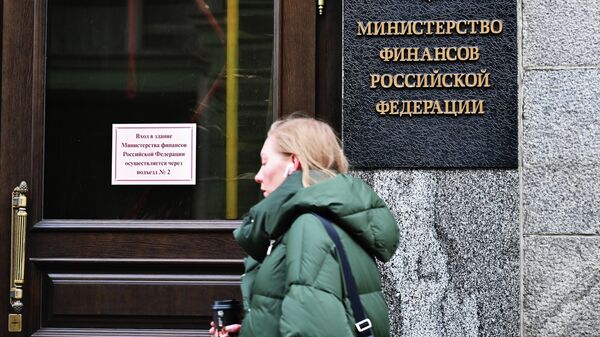 Женщина проходит рядом со зданием Министерства финансов России на улице Ильинке в Москве