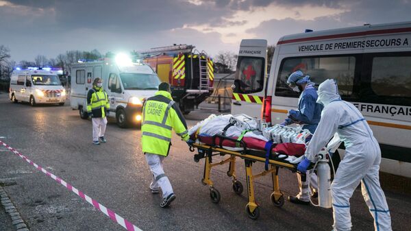 Медицинские работники везут пациента с коронавирусной инфекцией в городе Мюлуз, Франция