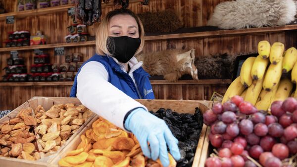 Продавец в защитной маске изображен на курорте Красная Поляна в Сочи, Россия