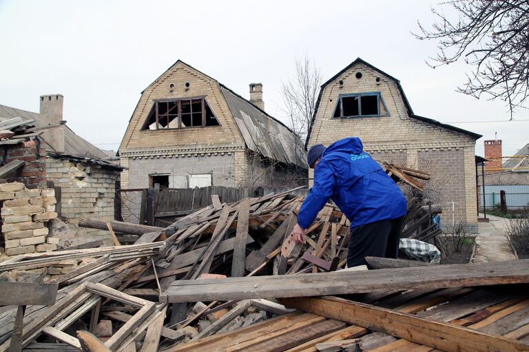 Местный житель во дворе частного дома, разрушенного после ночного артобстрела по Петровскому району Донецка