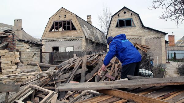 Местный житель во дворе частного дома, разрушенного после ночного артобстрела по Петровскому району Донецка