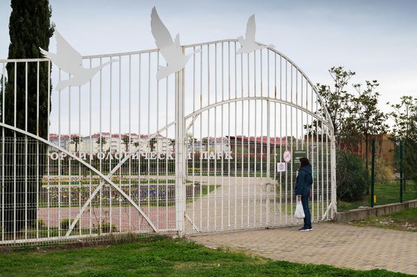Женщина читает объявление о закрытие орнитологического парка в Сочи