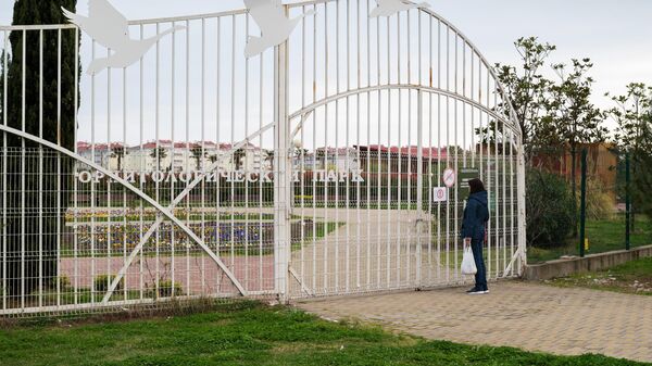 Женщина читает объявление о закрытие орнитологического парка в Сочи