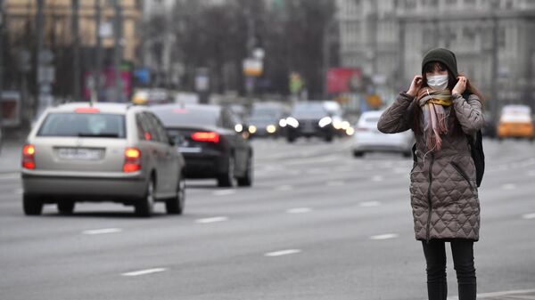 Девушка в защитной маске на улице Москвы