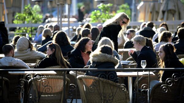 Посетители открытой веранды одного из ресторанов в Стокгольме во время пандемии коронавируса COVID-19 