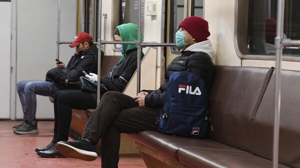 Пассажиры в медицинских масках в вагоне метро в Москве