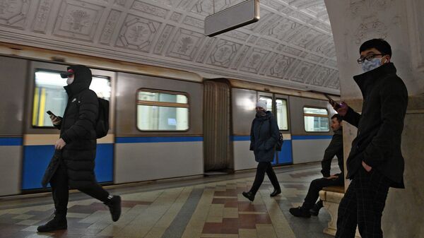 Пассажиры в медицинских масках на одной из станций метро в Москве
