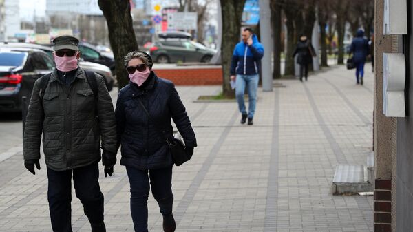 Прохожие в защитных масках на одной из улиц в Калининграде