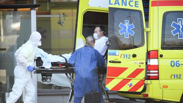 Сотрудники скорой помощи отправляют пациента с подозрением на коронавирус в больницу Бернховена в Нидерландах
