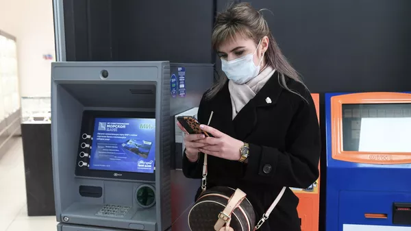 Девушка стоит возле банкомата
