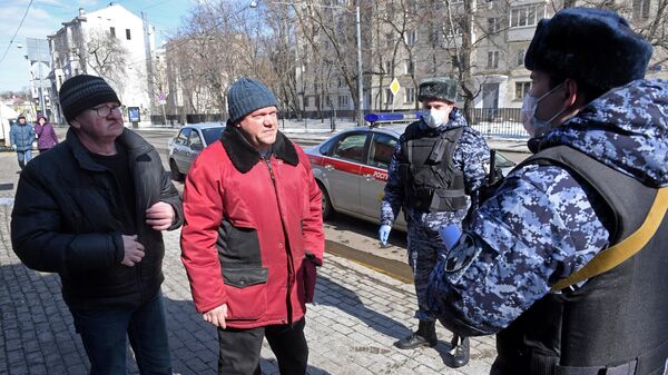 Сотрудники Росгвардии во время раздачи горожанам памяток по профилактике коронавирусной инфекции на одной из улиц в Москве