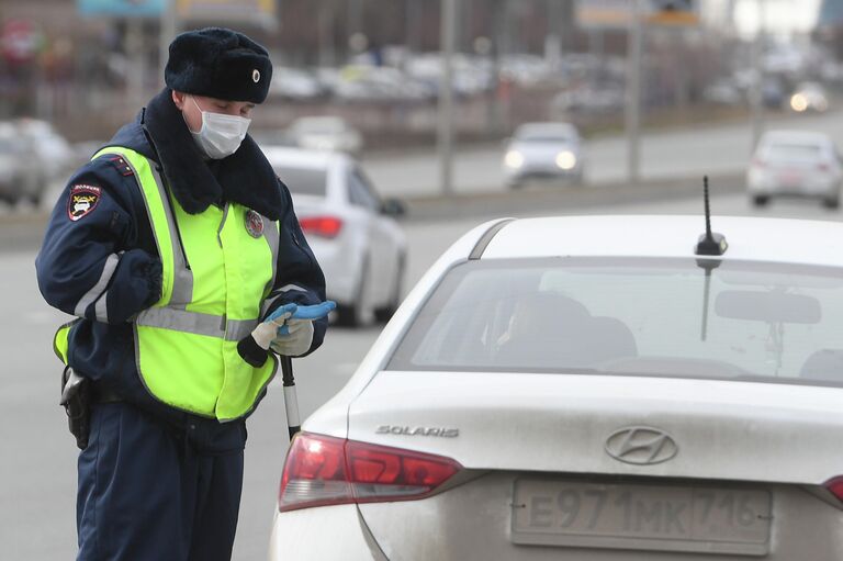 Сотрудник полиции в защитной маске во время специальных мероприятий МВД и Росгвардии по оповещению водителей о необходимости соблюдения правил самоизоляции Сотрудник полиции в защитной маске во время специальных мероприятий МВД и Росгвардии по оповещению водителей о необходимости соблюдения правил самоизоляции