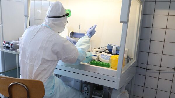 Сотрудник лаборатории выполняет анализы на коронавирус