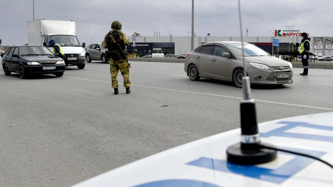 Сотрудник полиции в защитной маске во время специальных мероприятий МВД и Росгвардии на въезде в город Казань 