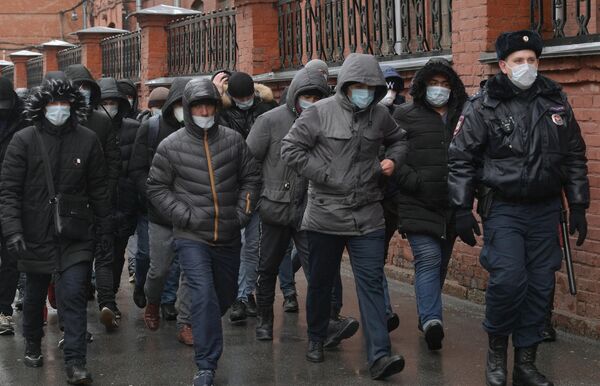 Сотрудник полиции выстраивает в очередь мигрантов у здания УФМС в Санкт-Петербурге Сотрудник полиции выстраивает в очередь мигрантов у здания УФМС в Санкт-Петербурге