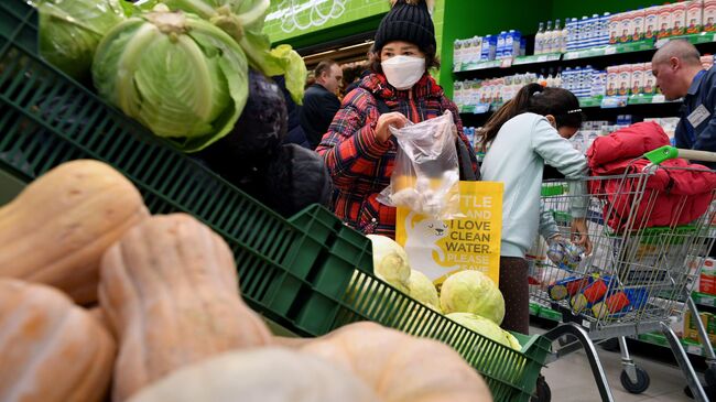 Покупательница выбирает чеснок в одном из супермаркетов в Москве