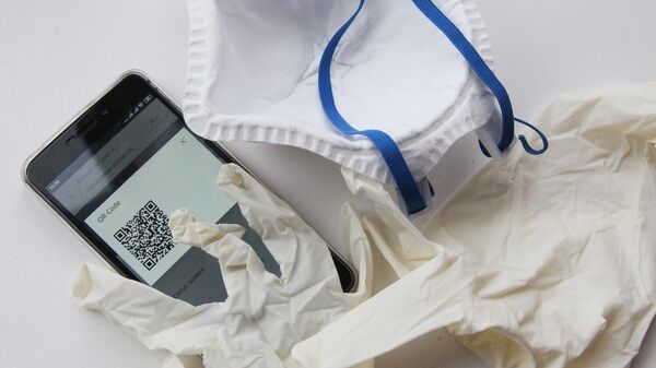 Перчатки, маска и смартфон жителя Нижегородской области с QR-кодом для предъявления сотруднику полиции при проверке режима самоизоляци