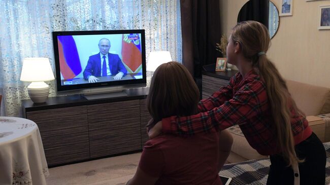 Жители Москвы смотрят трансляцию обращения президента РФ Владимира Путина к гражданам