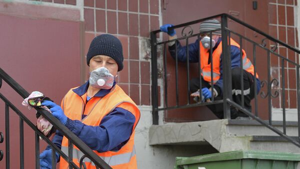 Сотрудники коммунальной службы проводят санитарную обработку парадной в Санкт-Петербурге