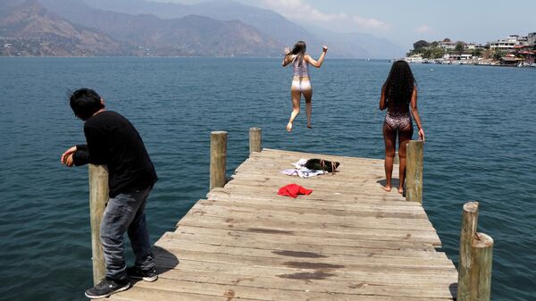 Девушка прыгает в воду в Сан-Педро-Ла-Лагуна, Солола, Гватемала 