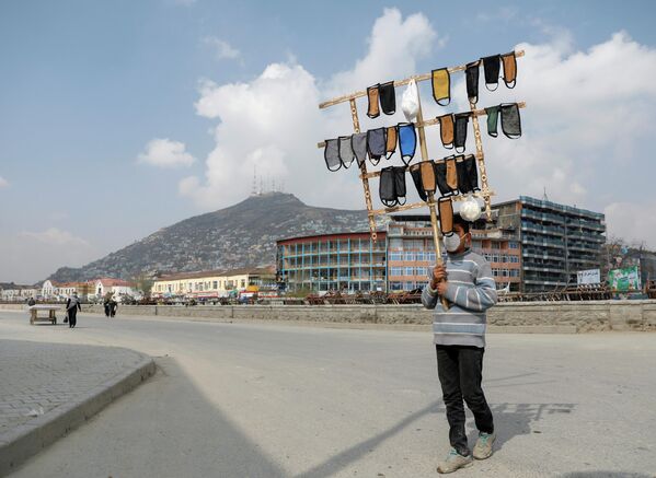 Афганский мальчик продает защитные маски в Кабуле