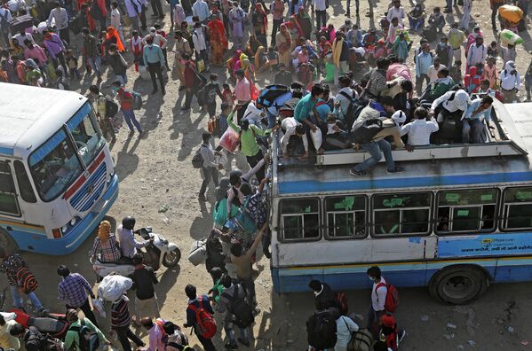 Трудовые мигранты едут в переполненных автобусах, чтобы вернуться в свои города и деревни во время режима изоляции из-за пандемии коронавируса в Газиабаде, Индия