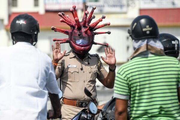 Полицейский в шлеме с коронавирусной тематикой на контрольно-пропускном пункте в Ченнае, Индия