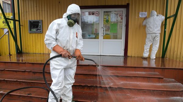 Сотрудник коммунальной службы проводит дезинфекцию у торговых рядов в городе Кировск в Ленинградской области