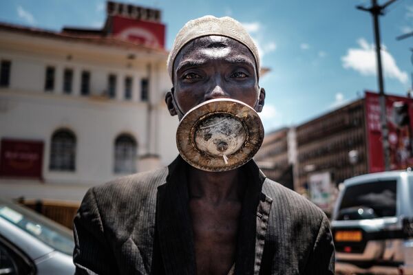 Мужчина в альтернативной маске в Кампале, Уганда